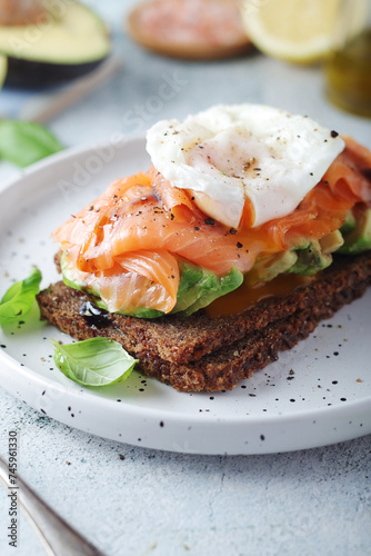 A rye bread sandwich with avocado and salmon