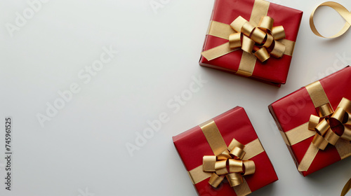 Red gift box wrapped around with golden ribbon on a white background