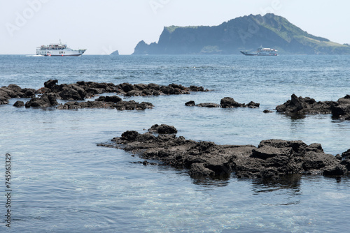 The beach of black rocks at the island seaside © 안구정화