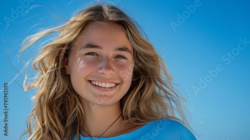 Young Woman Smiling Her Hair is Blown by the Wind - Blue Background Seeing The Upper Body when wearing Blue Clothes in Summer and The Sun is Bright Wallpaper created with Generative AI Technology © Sentoriak