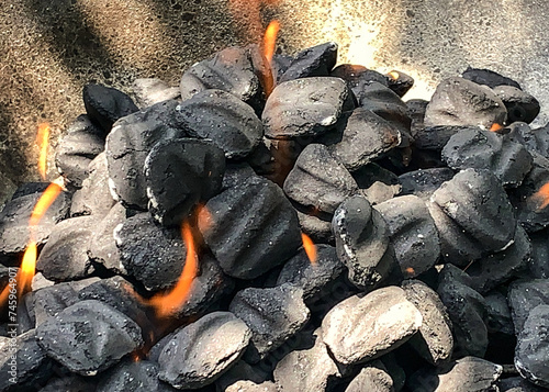 Charcoal briquettes on fire in a kettle grill