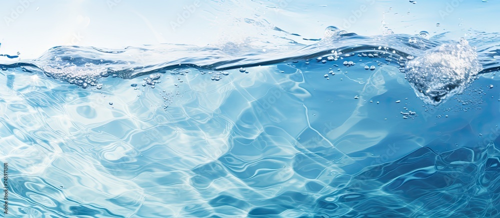 In the blue ocean, waves are crashing against the surface, creating splashes and ripples. The water is clear and transparent with bubbles, under the sunlight.