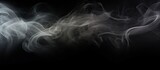 A black and white picture showing abstract smoke creating a textured frame on a dark black background. The swirling patterns of the smoke give a mysterious atmosphere.