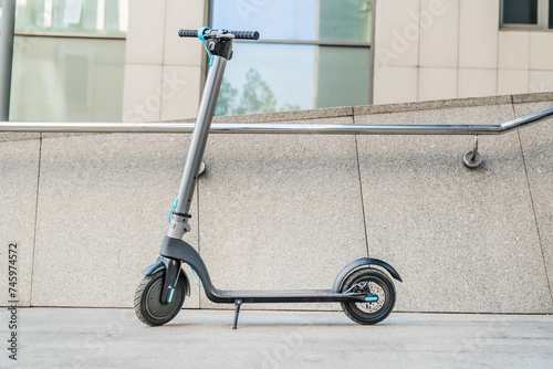 Electric scooter near business center street wall. E-transportation. Sustainable ecologically clean sound way of transportation. Environmentalism