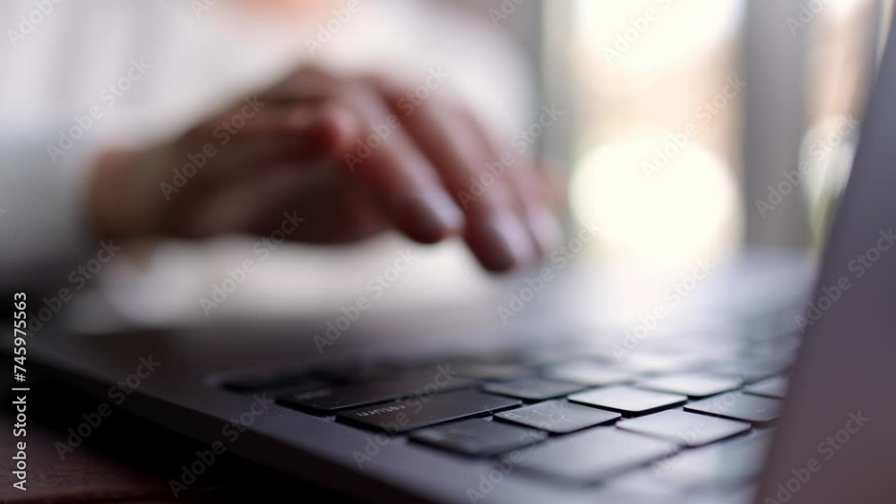Close-up of hands of unrecognizable businesswoman typing on laptop keyboard while working online. The concept of remote work online, freelancing and successful business.