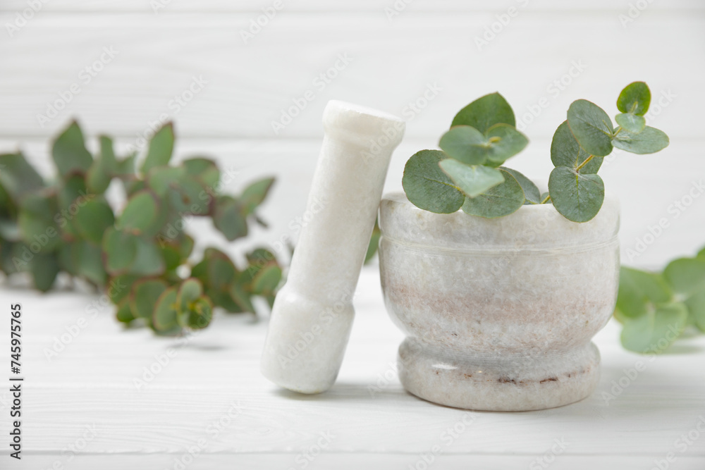 Eucalyptus leaves and mortar on a wooden background.Spa concept.Ingredients for alternative medicine and natural cosmetics. A bottle of essential oil and a bunch of eucalyptus. Organic skin care 