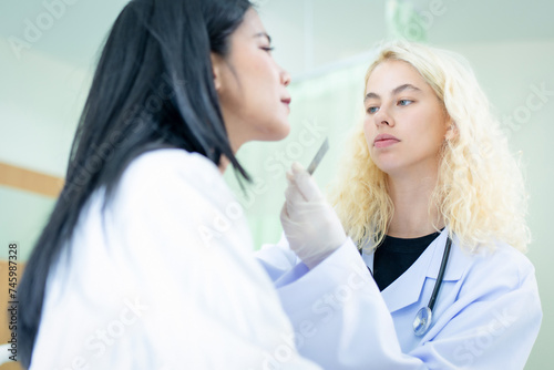 Professional woman doctor consultation in cosmetology clinic. Female professional beauty doctor talking with pretty young female.