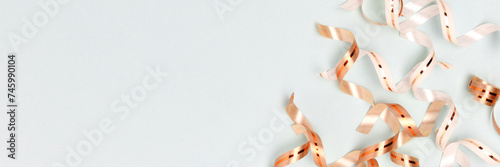 Banner with golden ribbons on a blue pastel background with place fro text. Selective focus. photo