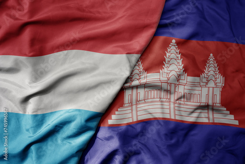 big waving national colorful flag of cambodia and national flag of luxembourg .