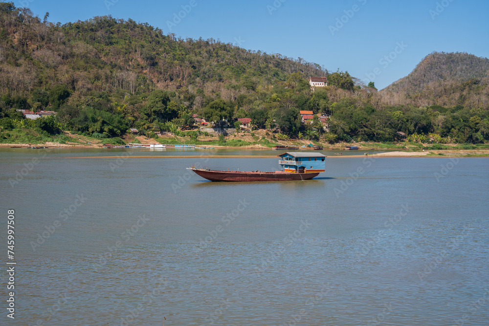 Obraz premium Laotian wooden boats on the Mekong River in Luang Prabang in Laos Southeast Asia