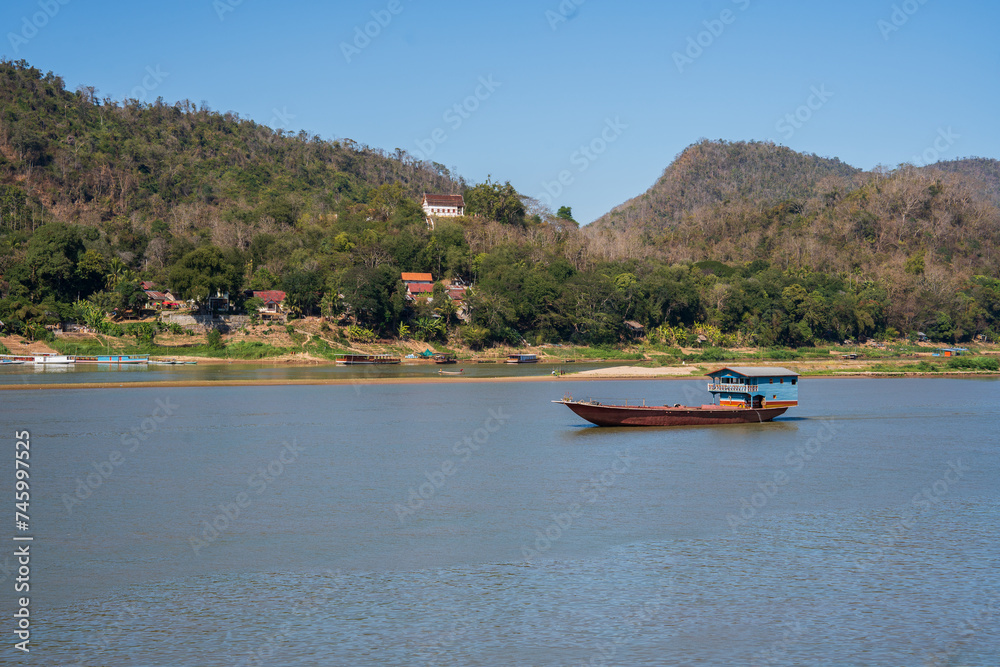 Obraz premium Laotian wooden boats on the Mekong River in Luang Prabang in Laos Southeast Asia