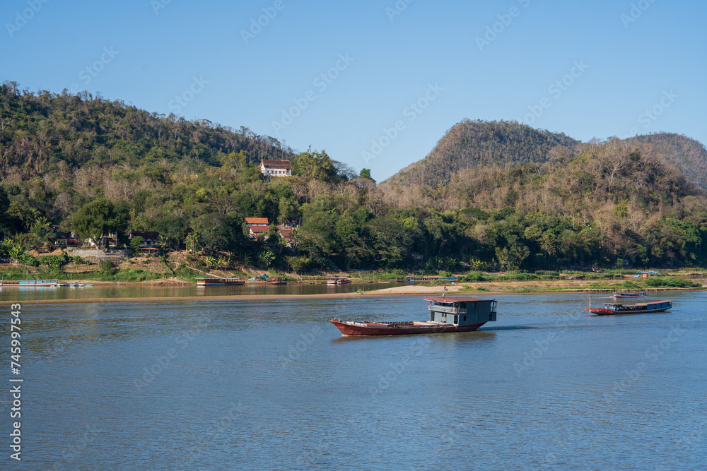 Obraz premium Laotian wooden boats on the Mekong River in Luang Prabang in Laos Southeast Asia
