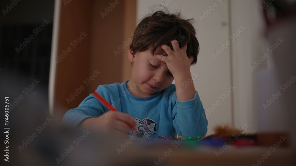 One happy little boy drawing at home wearing pajamas in the evening before bedtime. Child engaged in creative coloring on paper smiling One happy little boy drawing at home wearing pajamas in the evening before bedtime. Child engaged in creative coloring on paper smiling