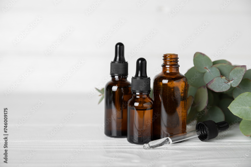 Eucalyptus essential oil in a glass bottle with green eucalyptus leaves on a textured wooden background. Aromatherapy concept. Spa. Natural organic ingredients for cosmetics and body care.Copy space Eucalyptus essential oil in a glass bottle with green eucalyptus leaves on a textured wooden background. Aromatherapy concept. Spa. Natural organic ingredients for cosmetics and body care.Copy space
