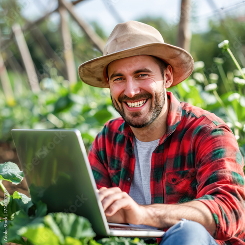 Young male agronomist using laptop at agriculture field