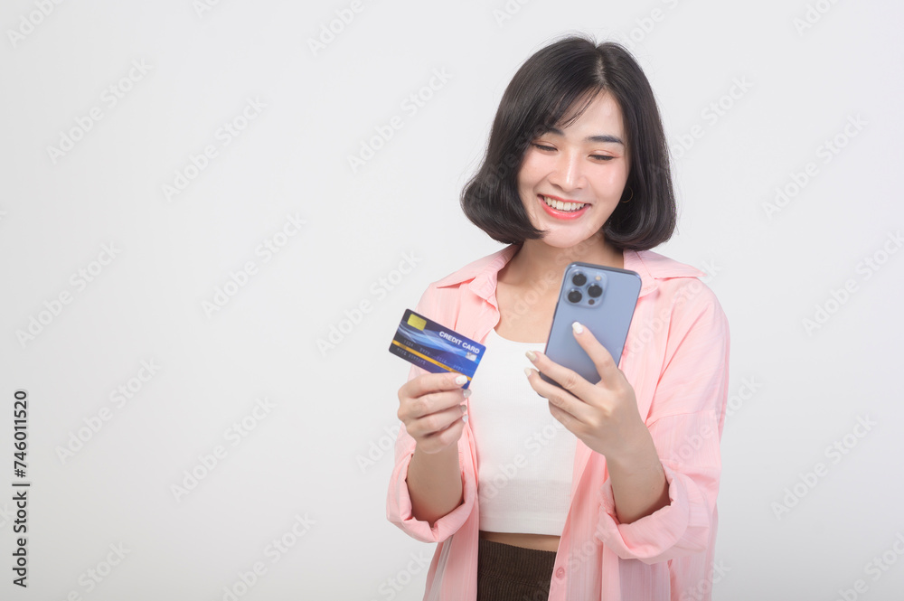 Asian smiling woman holding credit card over white background studio, shopping and finance concept. Asian smiling woman holding credit card over white background studio, shopping and finance concept.