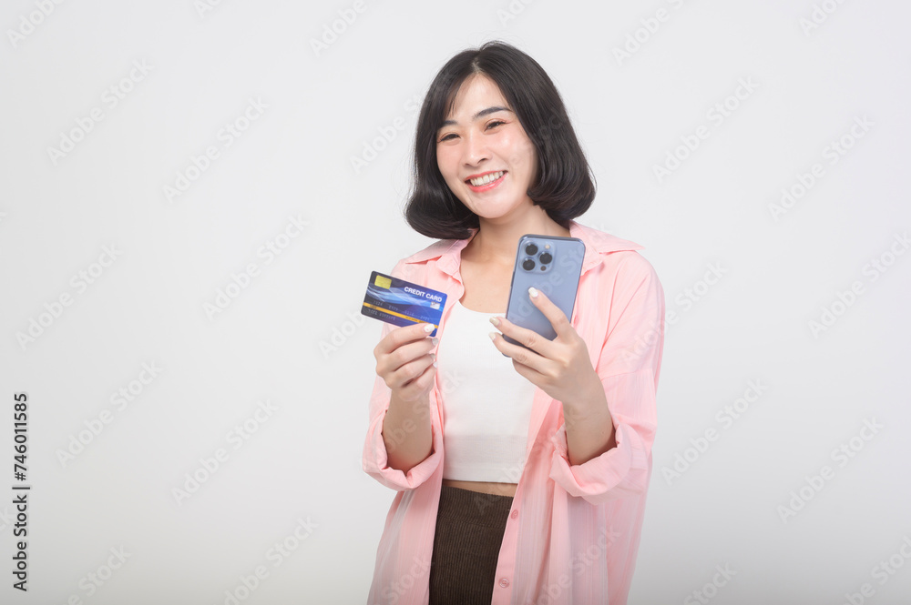 Asian smiling woman holding credit card over white background studio, shopping and finance concept. Asian smiling woman holding credit card over white background studio, shopping and finance concept.