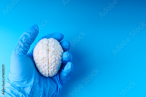 Hand of man in medical glove squeezing brain