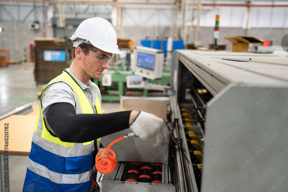 Portrait Caucasian working with holding air blow gun and control machine at Kraft paper factory at factory	