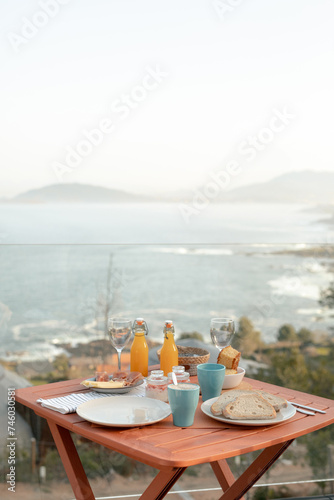 Breakfast table setup with sea view. Outdoor dining photography with copy space. Seaside resort and vacation dining concept