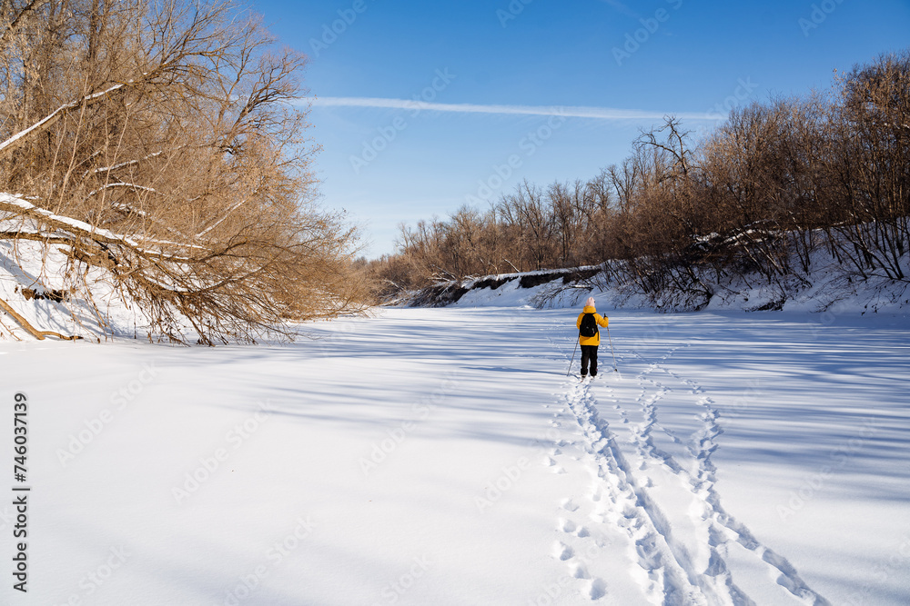 Person in yellow jacket cross country skiing on snowy slope