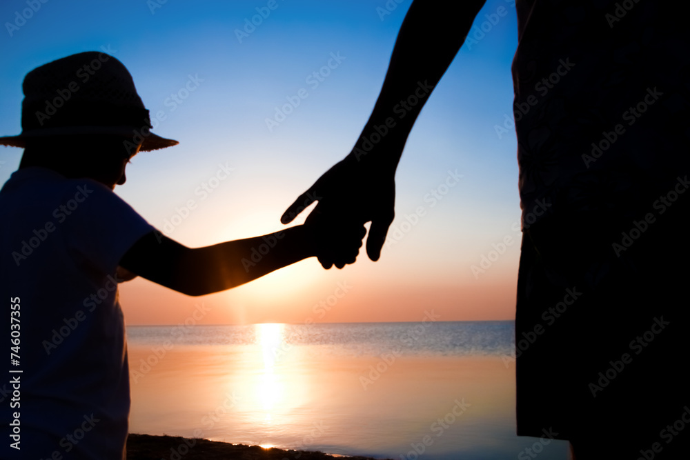 A Hands of happy father and child by the sea on nature silhouette travel