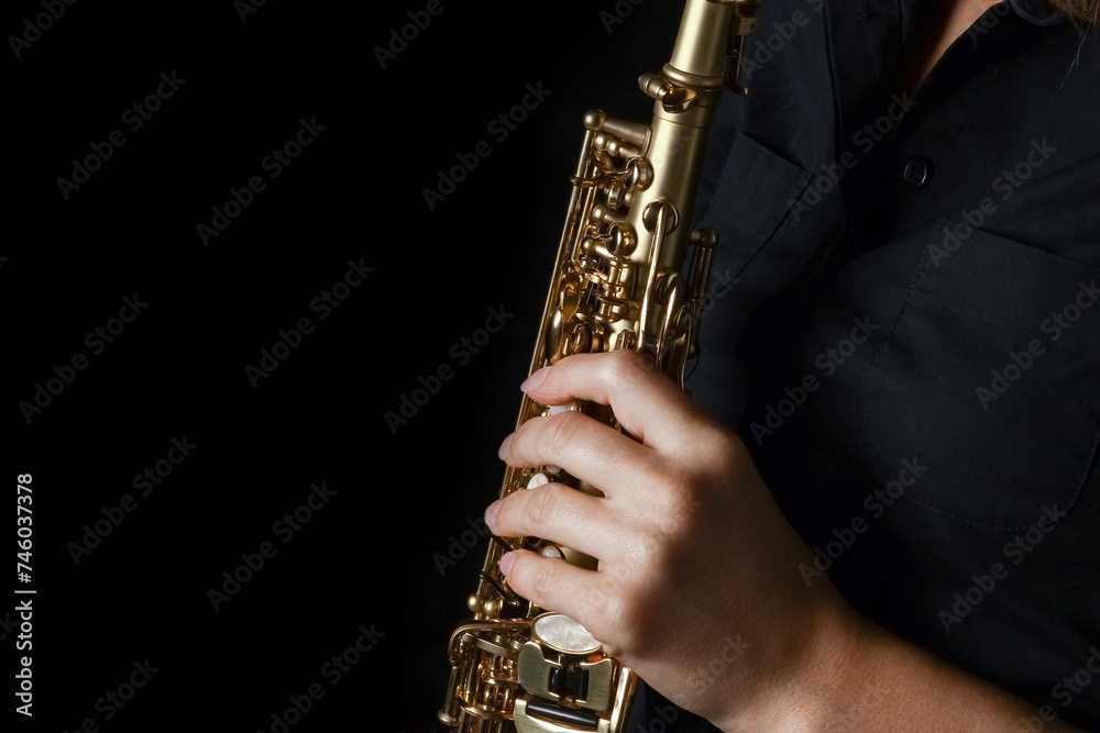 Fototapeta premium soprano saxophone in hands on a black background
