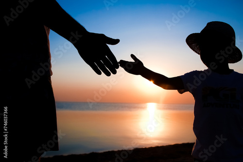 A Hands of happy father and child by the sea on nature silhouette travel