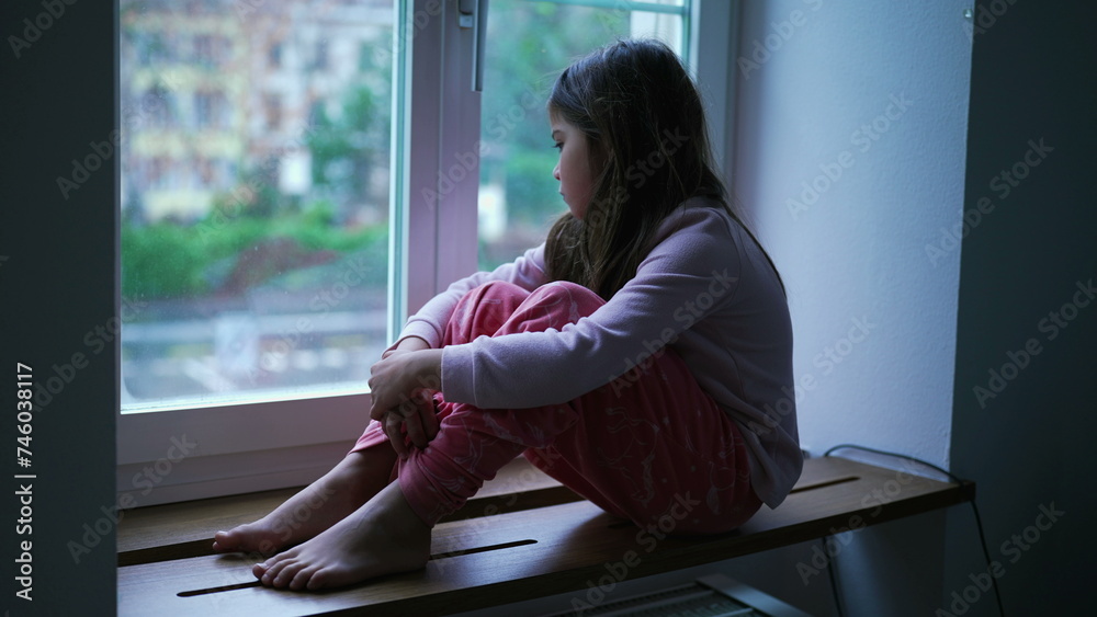 Depressed Little Girl by Window, Anxiety and Worry in Childhood. Child feeling lonely at home struggling with difficulties Depressed Little Girl by Window, Anxiety and Worry in Childhood. Child feeling lonely at home struggling with difficulties