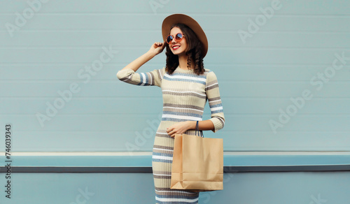 Stylish beautiful happy smiling young woman posing with shopping bags on city street