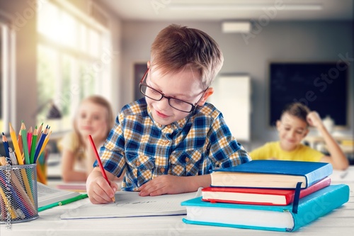 School children writing learning in class