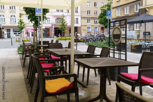 Fototapeta Naklejka Na Ścianę i Meble -  Outdoor Dining Area With Tables, Chairs, and Umbrellas