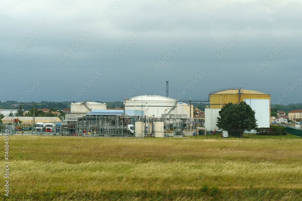 Cloudy day at an industrial oil refinery with storage tanks and pipelines Cloudy day at an industrial oil refinery with storage tanks and pipelines