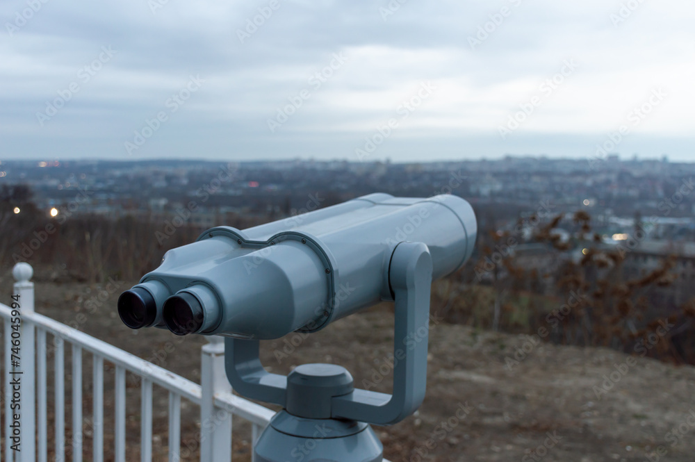 Grey binoculars at the observation deck on a cloudy day Grey binoculars at the observation deck on a cloudy day