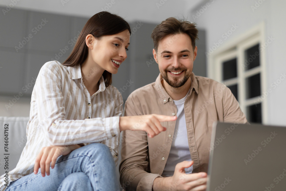 Spouses interacting with laptop computer at home Spouses interacting with laptop computer at home