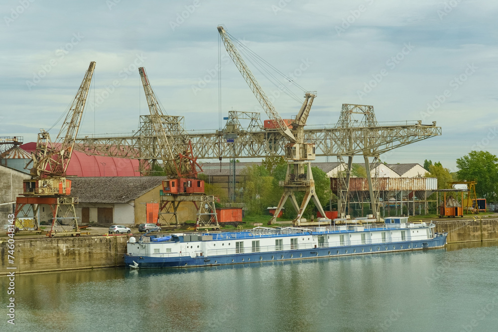 Industrial River Scene With Blue Cargo Barge and Cranes on an Overcast Day