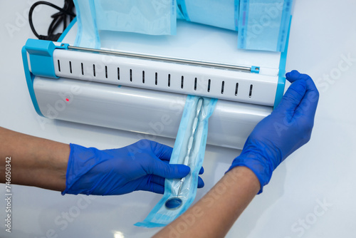 Doctor doing sterilization procedure hands in blue gloves holding dentist tools