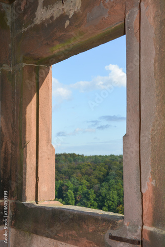 View through an old castle window on a sky and green landscape