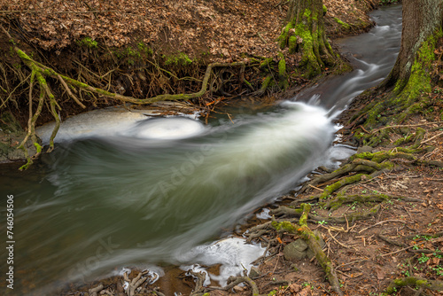 Uneticky creek with flooded water in winter spring evening in Prague photo