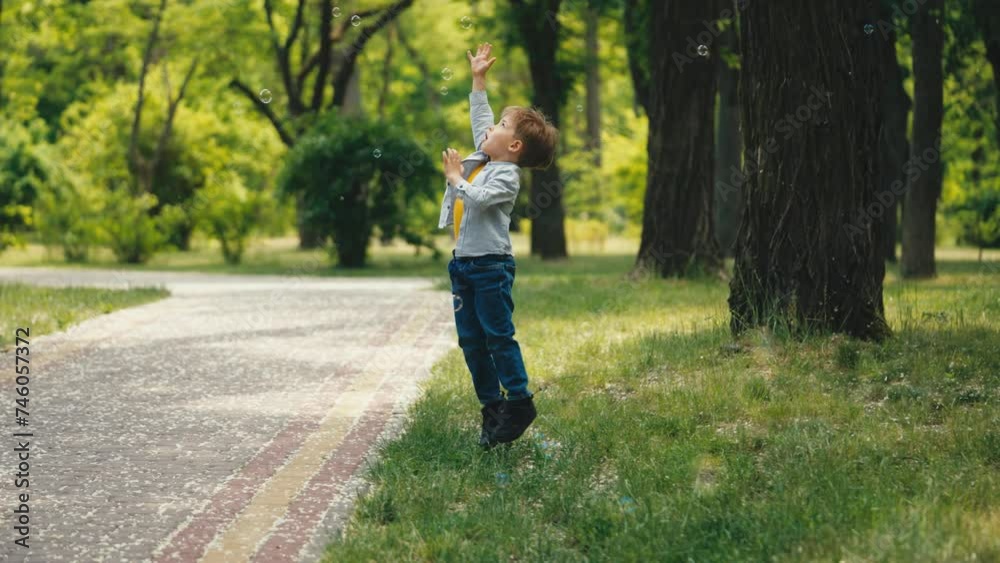 Excited 5-year-old boy trying to catch soap bubbles in urban park, happiness Excited 5-year-old boy trying to catch soap bubbles in urban park, happiness