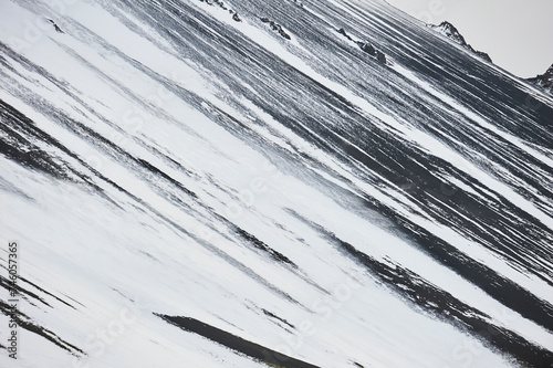 Abstract northen landscapes: A close-up view captures the contrasting snow and rock patterns on Hafnarfjall mountain slope near Borgarnes (region of Vesturland, Iceland) photo