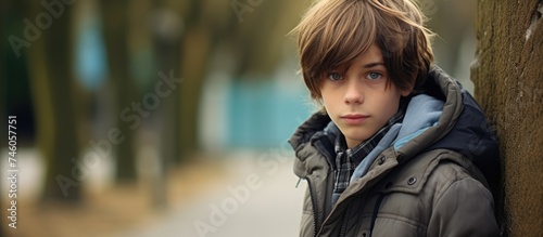 Confident Teen Boy Leaning Against Tree in Urban Park Setting