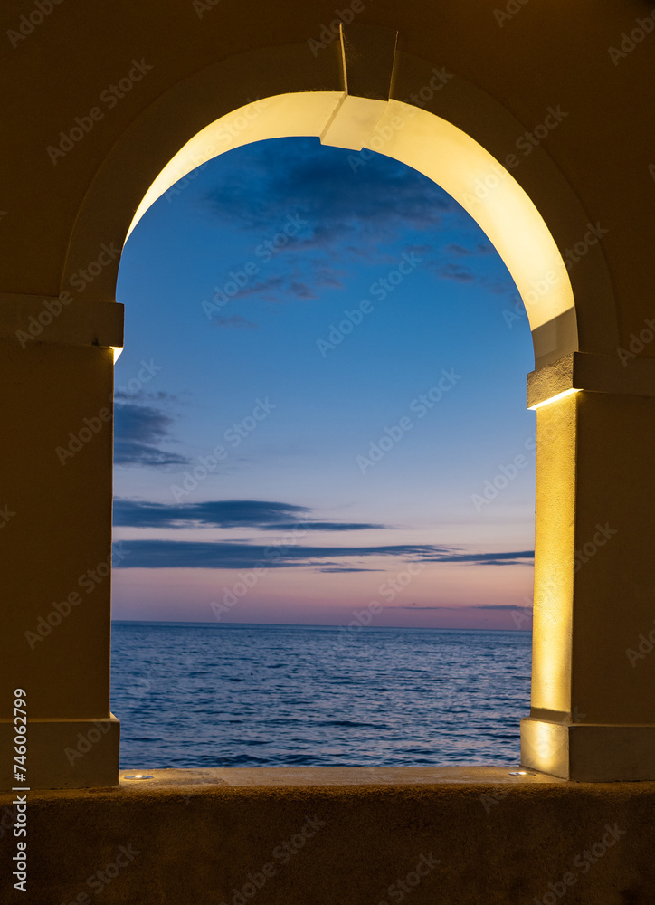 arch and window against sea at sunset