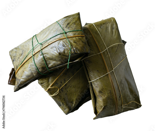 Three tamales wrapped in banana leaf on white background.