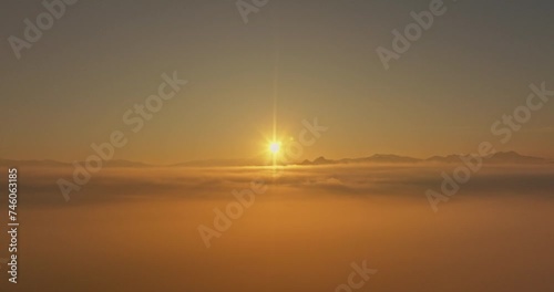 Aerial view amazing the sea of mist at beautiful sunrise..slow floating fog blowing cover on the top of mountain look like as a sea of mist. .white cloud in blue sky over the perfect forest. photo