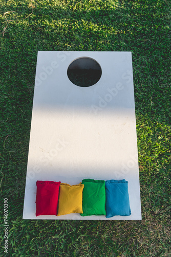 Cornhole (sack toss, or bags) is a lawn game popular in North America in which players or teams take turns throwing fabric bean bags at a raised, angled board with a hole in its far end