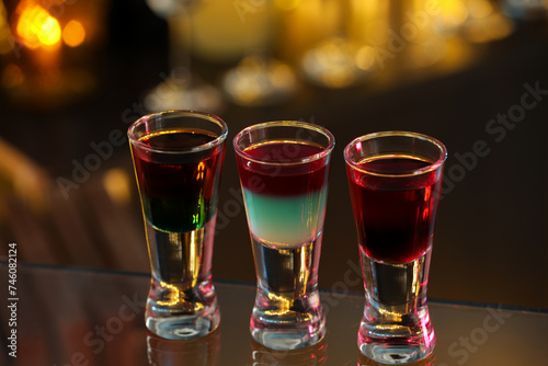 Different shooters in shot glasses on surface against blurred background Alcohol drink © New Africa
