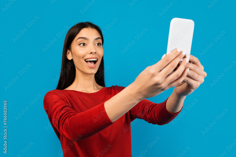 Naklejka premium Great App. Amazed Young Woman Looking At Smartphone Screen With Excitement