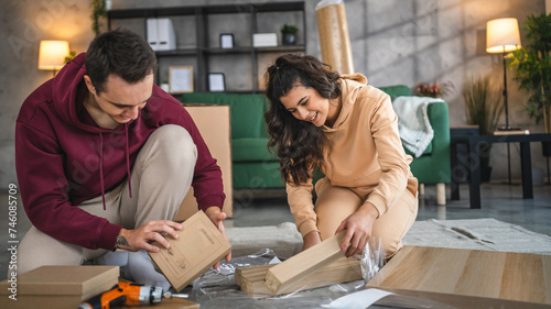 young couple moving in new apartment carry assembly furniture