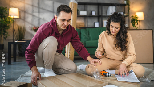 young couple moving in new apartment carry assembly furniture